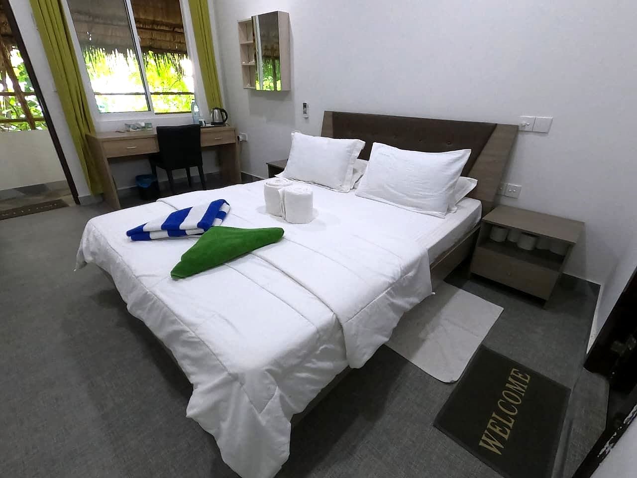 A Deluxe Double room at Dhangethi Inn, bed made with fresh towels