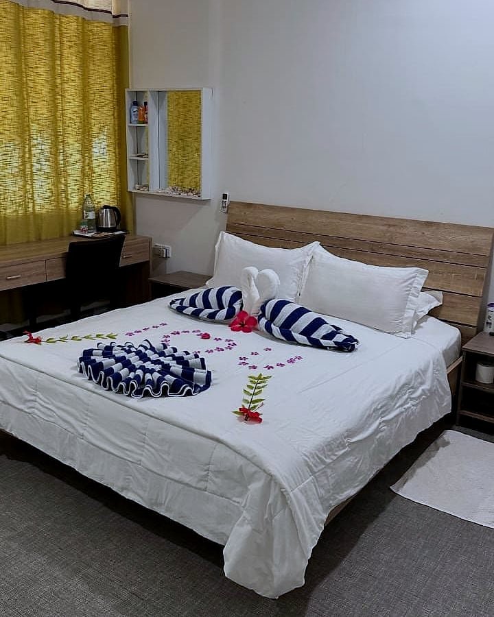 The Family Room bed dressed with towel art and petals